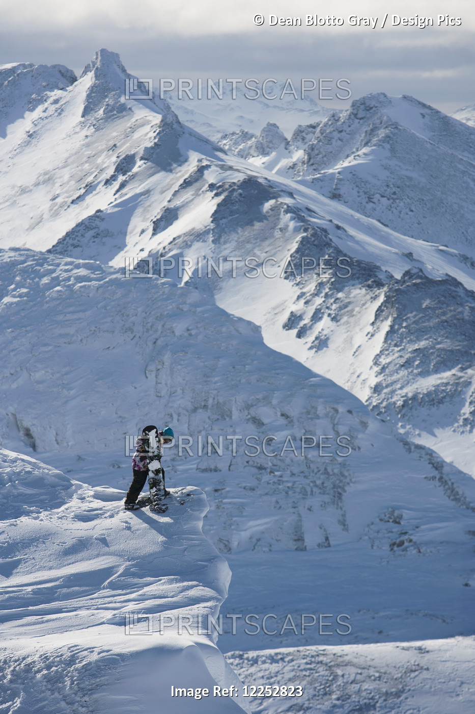 Professional Snowboarder Looking Over The Ledge At Extreme Terrain, Ushuaia, ...