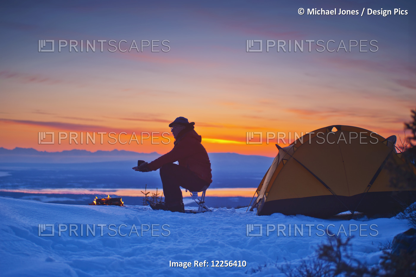 A Backpacker Warms His Hands Over A Campfire At A Campsite High In The Chugach ...