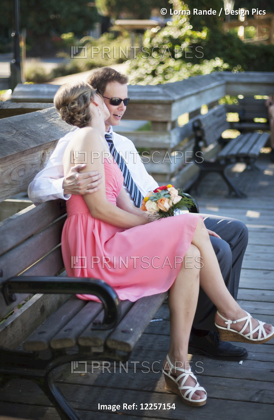 An Affectionate Couple Sitting On A Bench; Vancouver, British Columbia, Canada