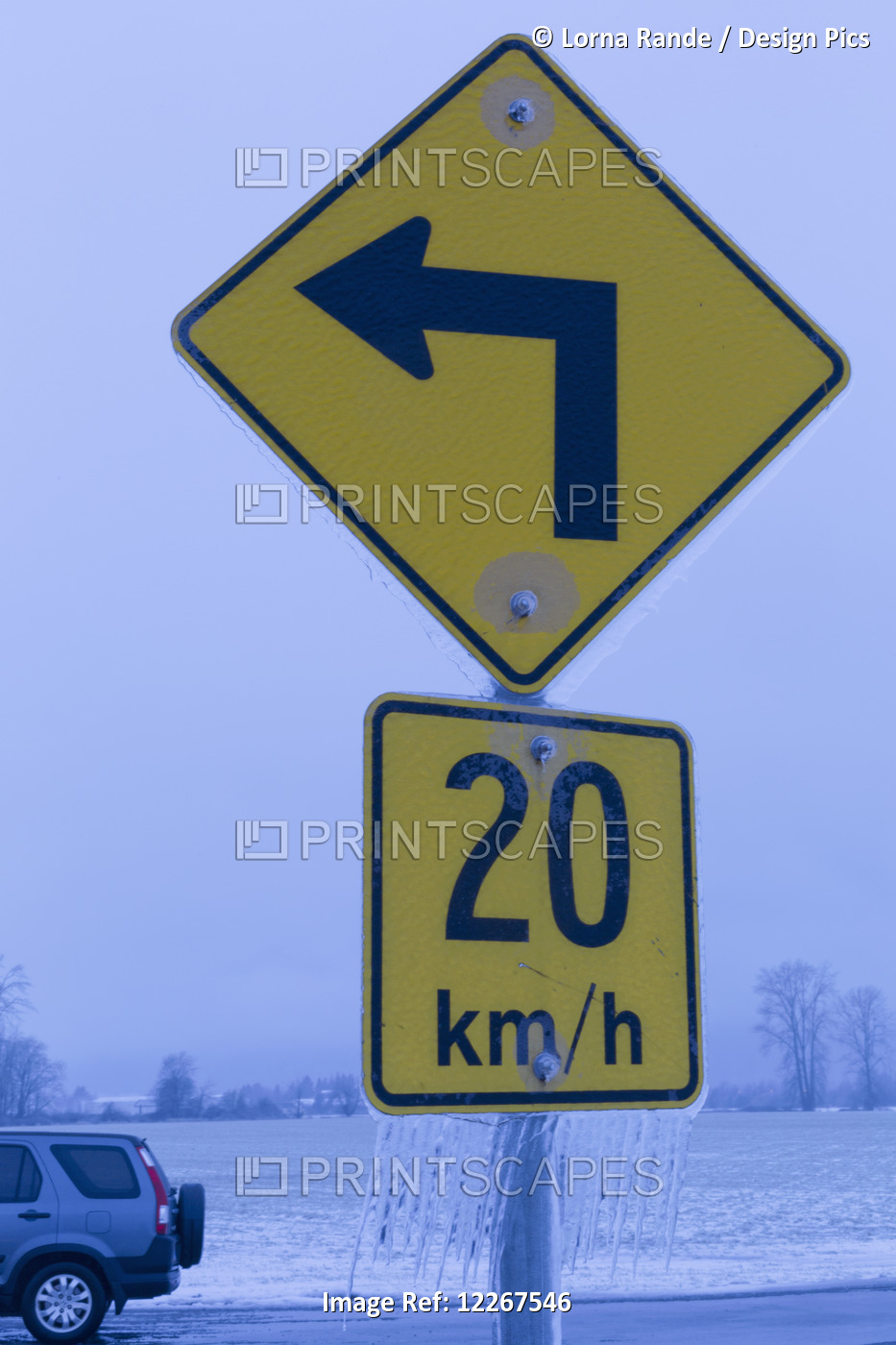 Road Sign Indicating Speed At Left Turn With Icicles Hanging From It; British ...