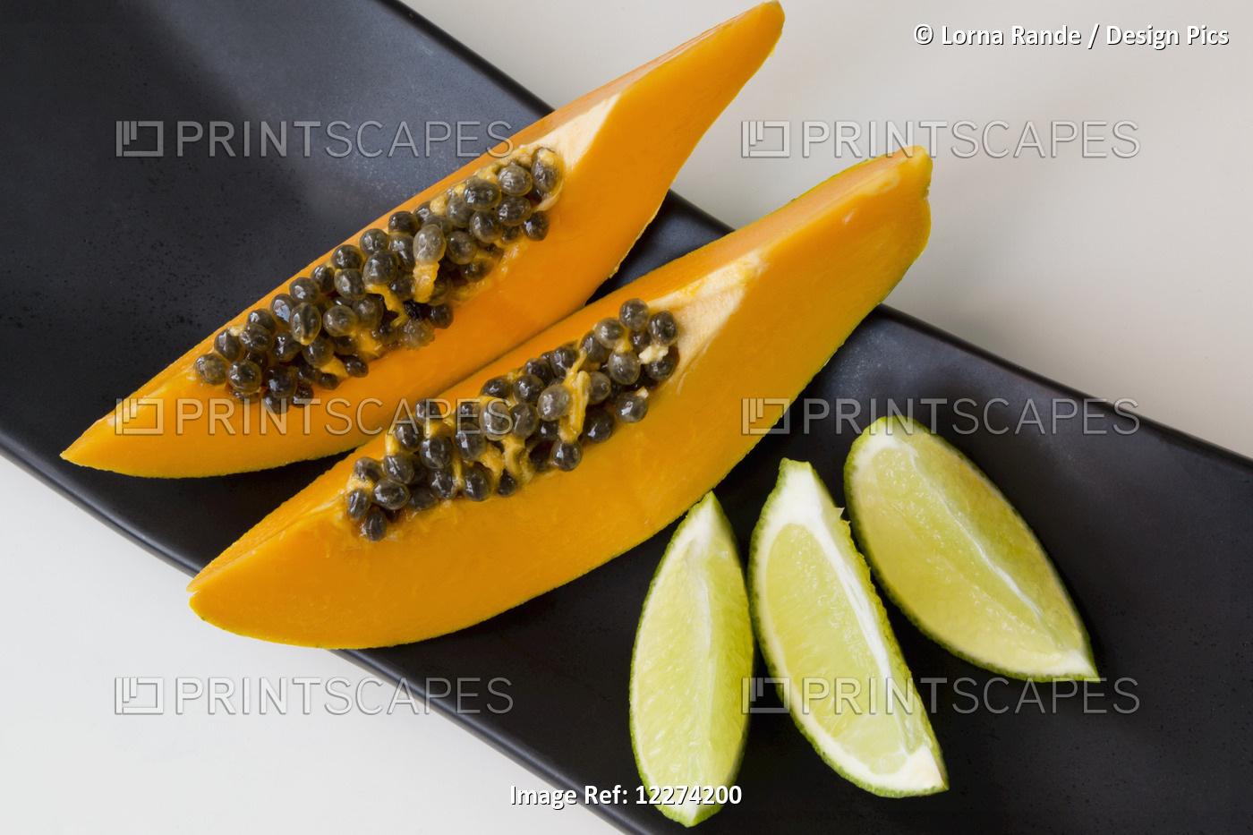 Papaya And Lime Slices On A Black Platter; Chilliwack, British Columbia, Canada