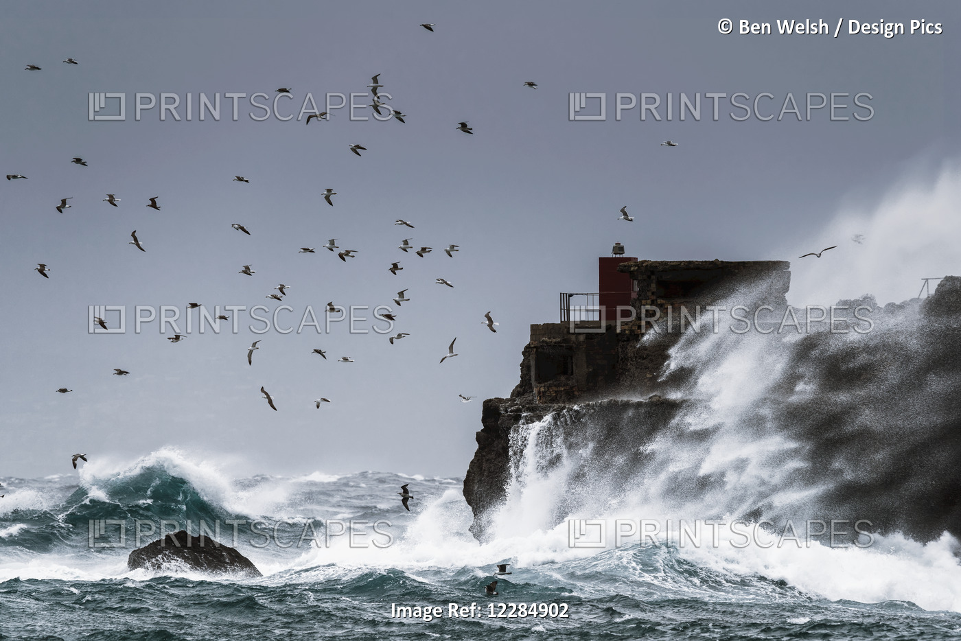 Waves Crashing Against The Rugged Rock Coastline As Birds Fly Overhead Against ...