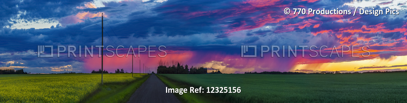Dramatic Colourful Sky At Sunset Over Green Farmland And A Country Road; ...