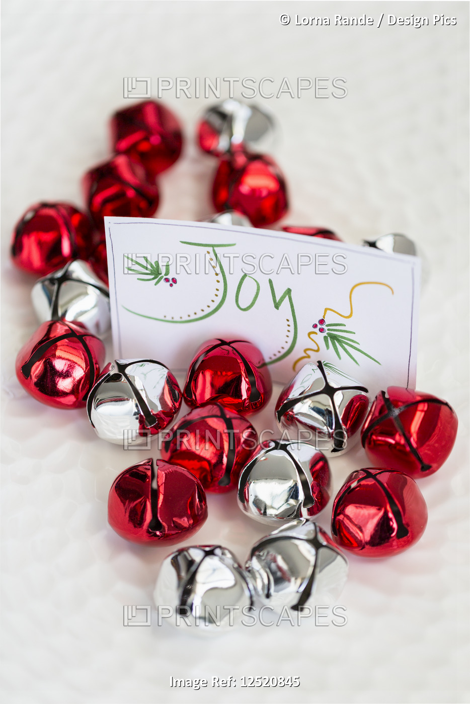 Red and silver bells with a sign saying joy for a Christmas decoration