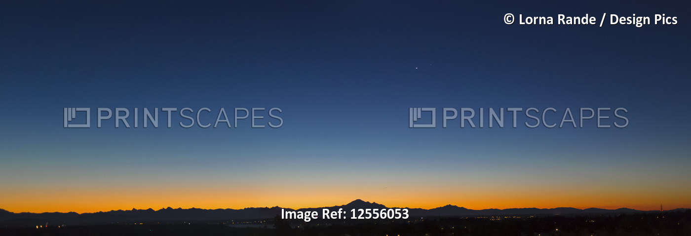 Sunset glowing over the horizon with a blue, starry sky; Surrey, British ...