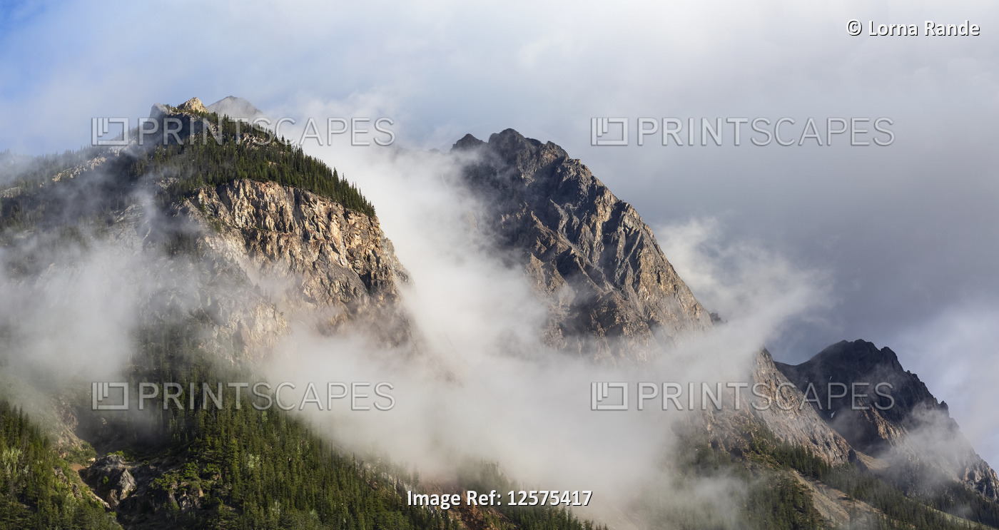 Clouds gather around Rocky mountain peaks; Field, British Columbia, Canada