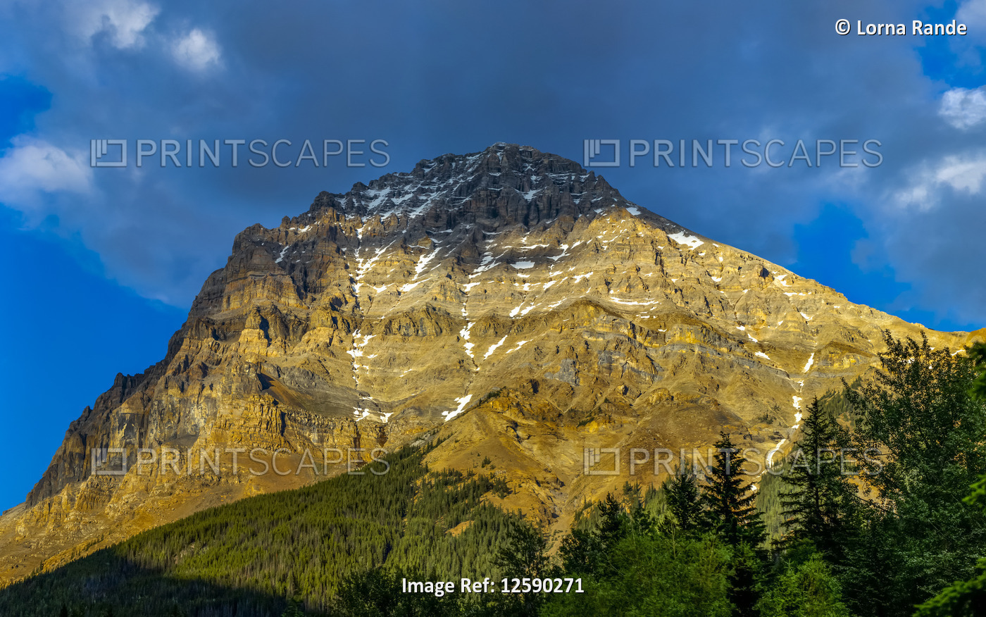 Rugged mountain in the Canadian Rocky mountains illuminated by sunlight with a ...