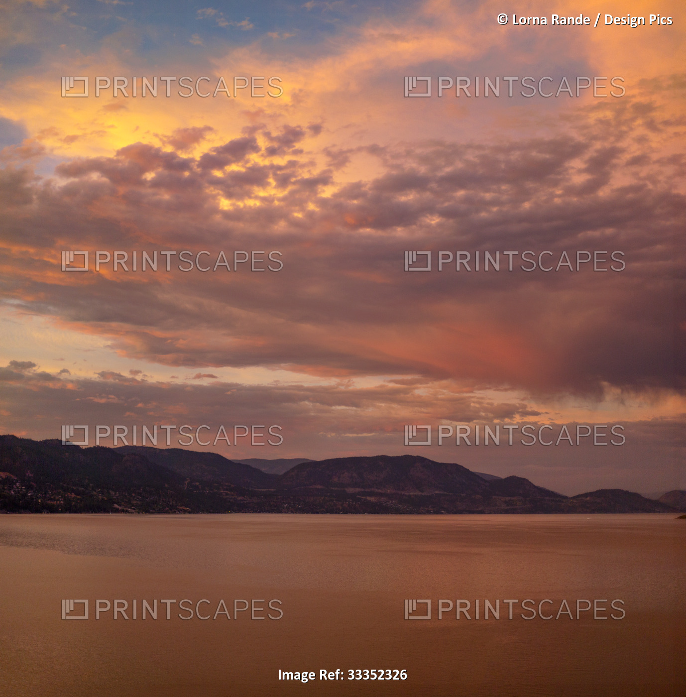 Dramatic glowing clouds over Okanagan Lake at sunset with the silhouetted Coast ...