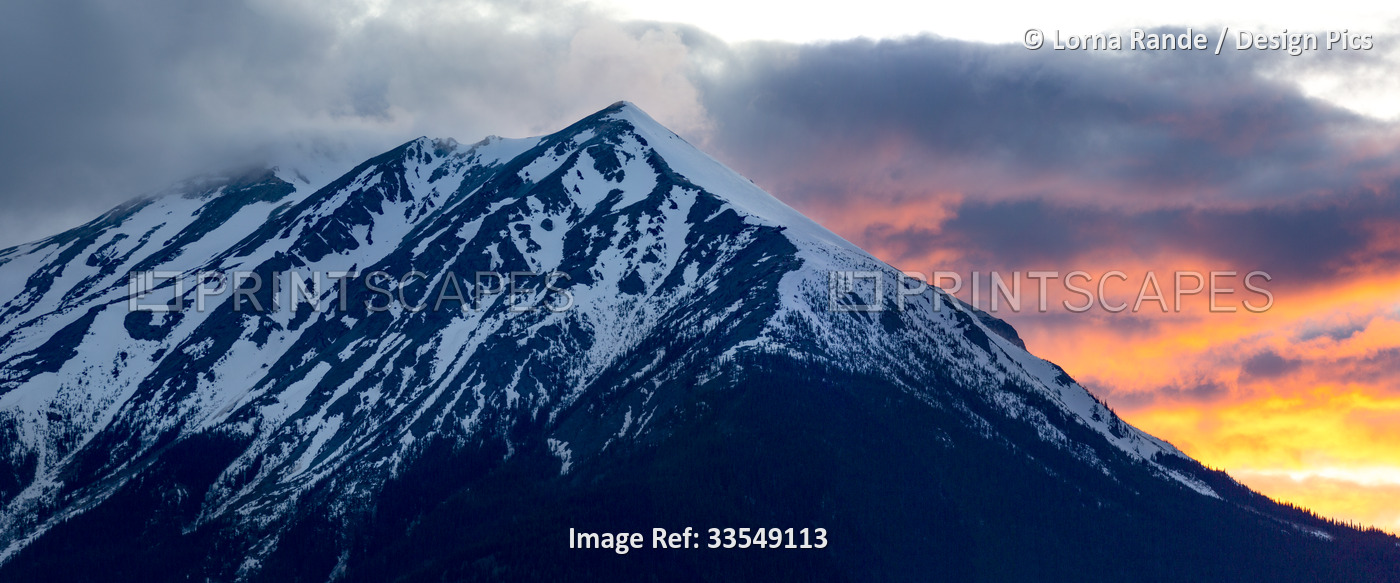 Rugged peak of Hudson Bay Mountain covered in snow with colourful glowing ...