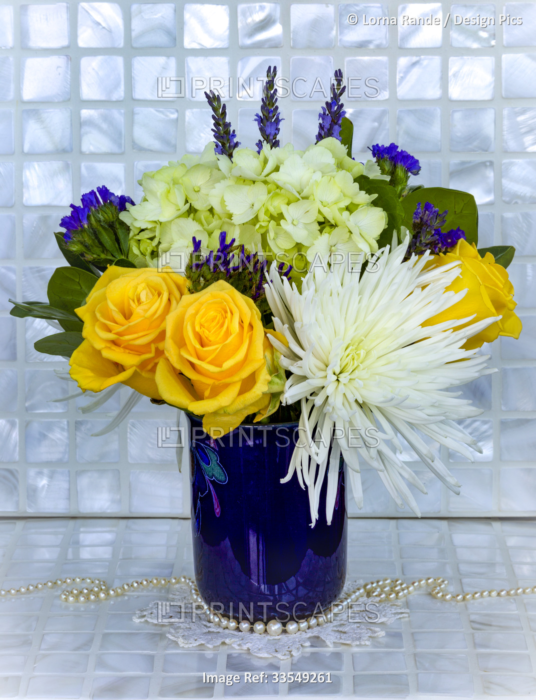 Bouquet of fresh cut flowers in a blue vase with a crocheted doily and pearls, ...