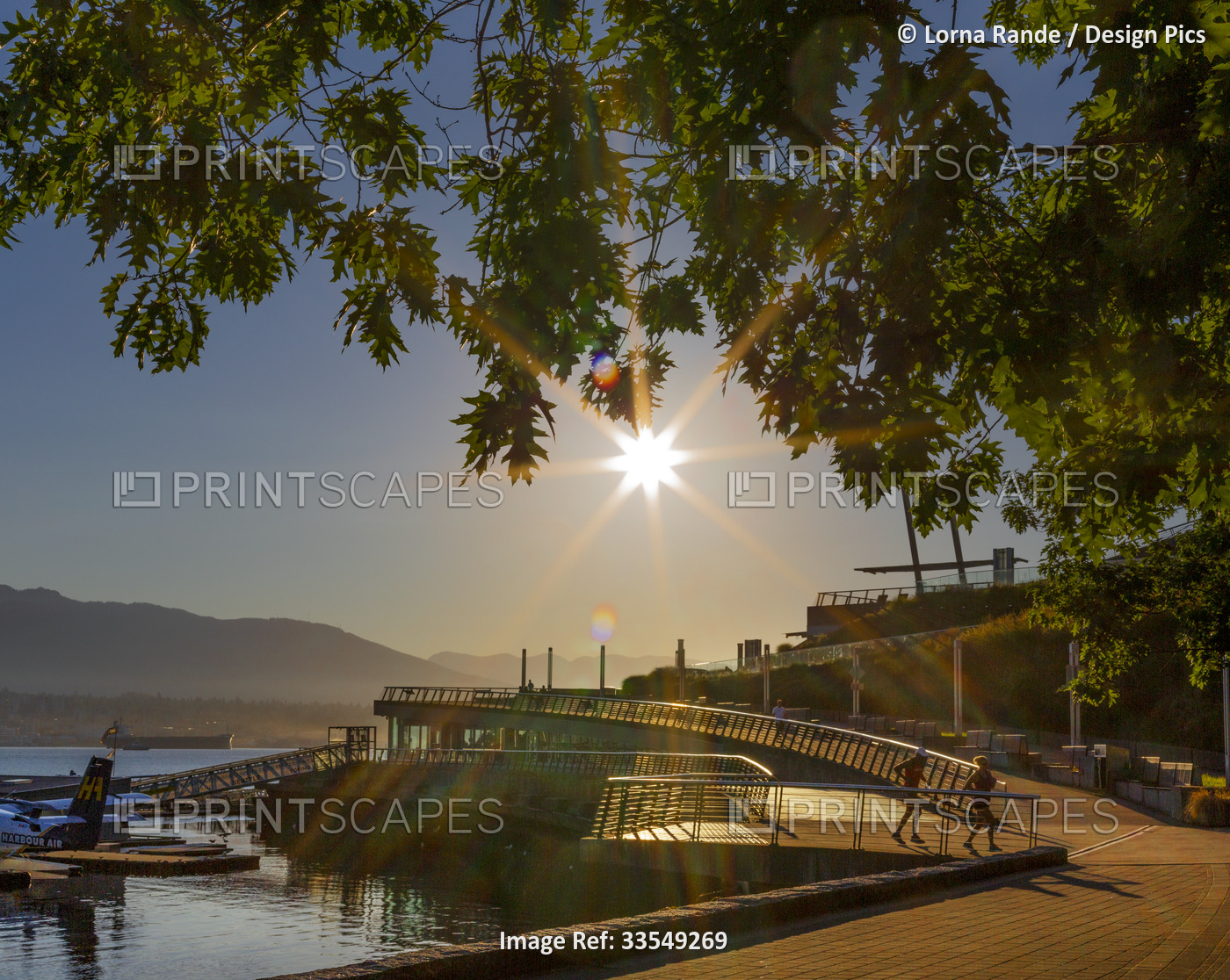 Sunburst over the Vancouver waterfront and promenade, BC, Canada; Vancouver, ...