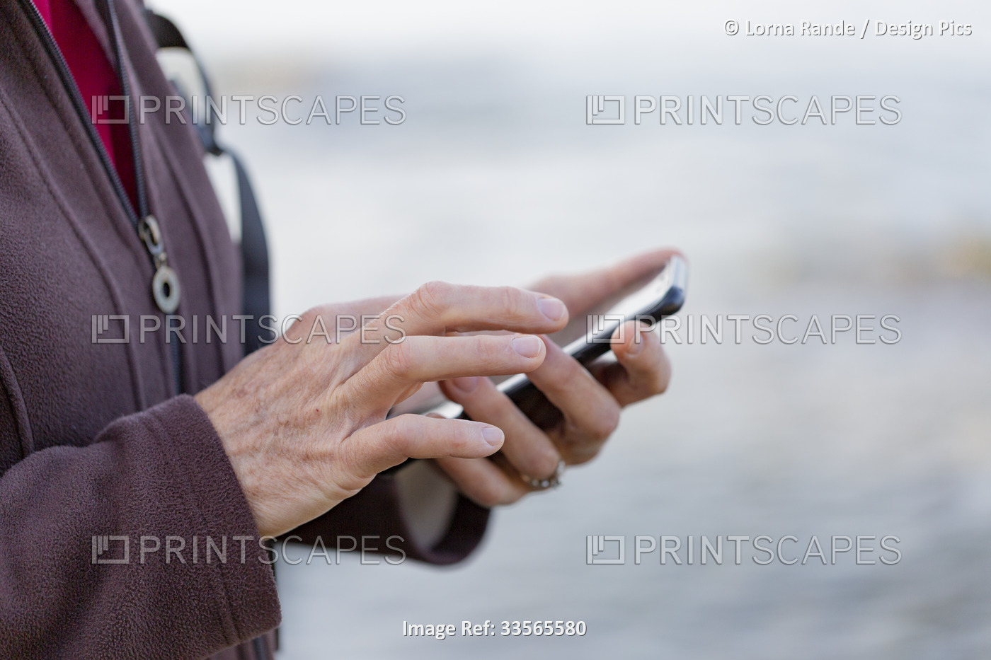 Close-up detail of a woman's hands using a smart phone while hiking; British ...