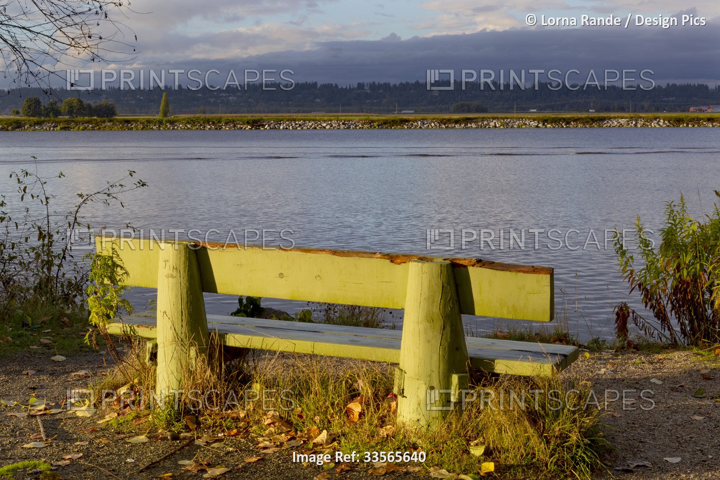 Bench along a path at the water's edge with a view of the Pacific Ocean water, ...