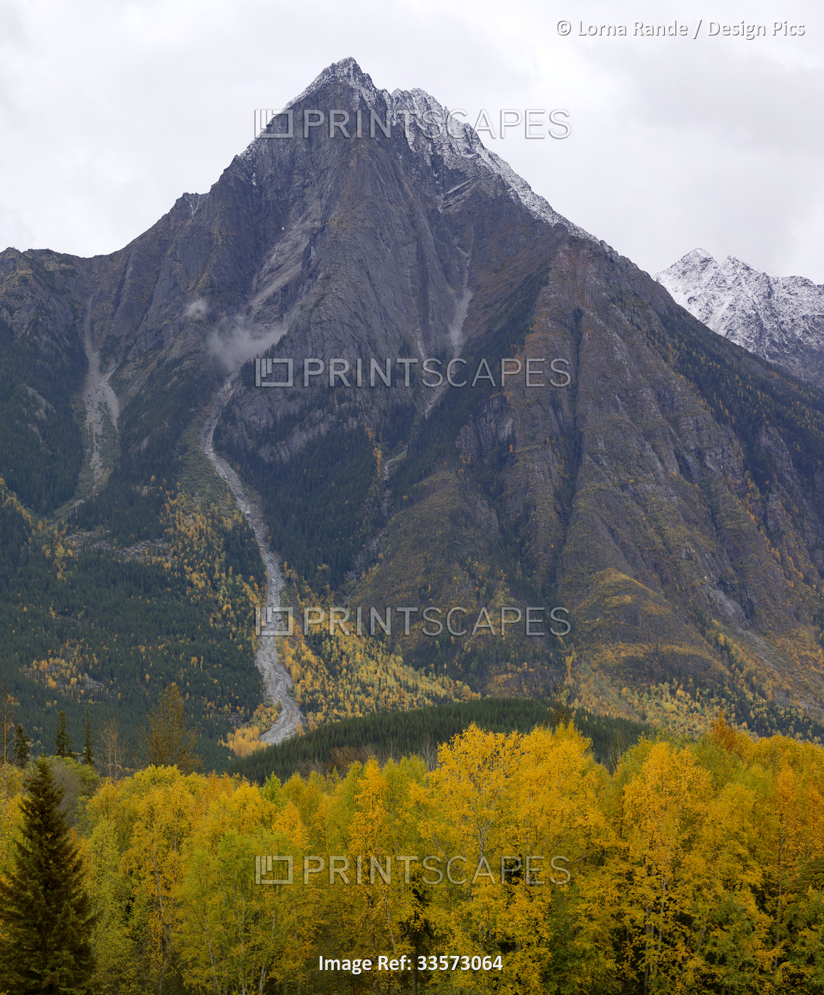 Vast and dramatic landscape of rugged mountain peaks under a cloudy sky and an ...