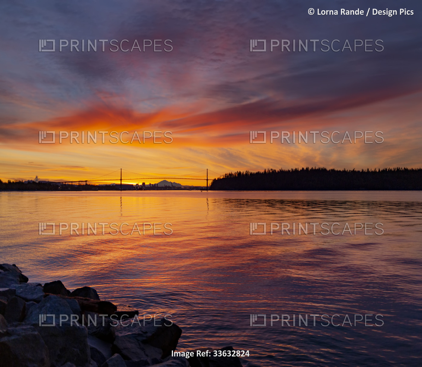 Brilliant colours of a sunrise viewed from the seawall in West Vancouver; West ...