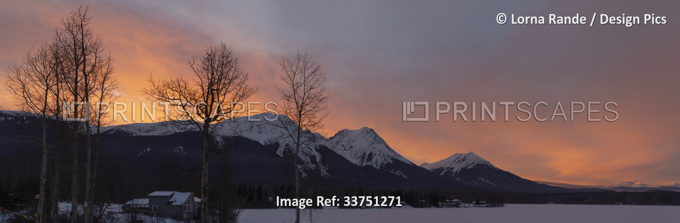 Sky glowing pink over snow-capped mountains from Watson's Landing, Smithers, ...