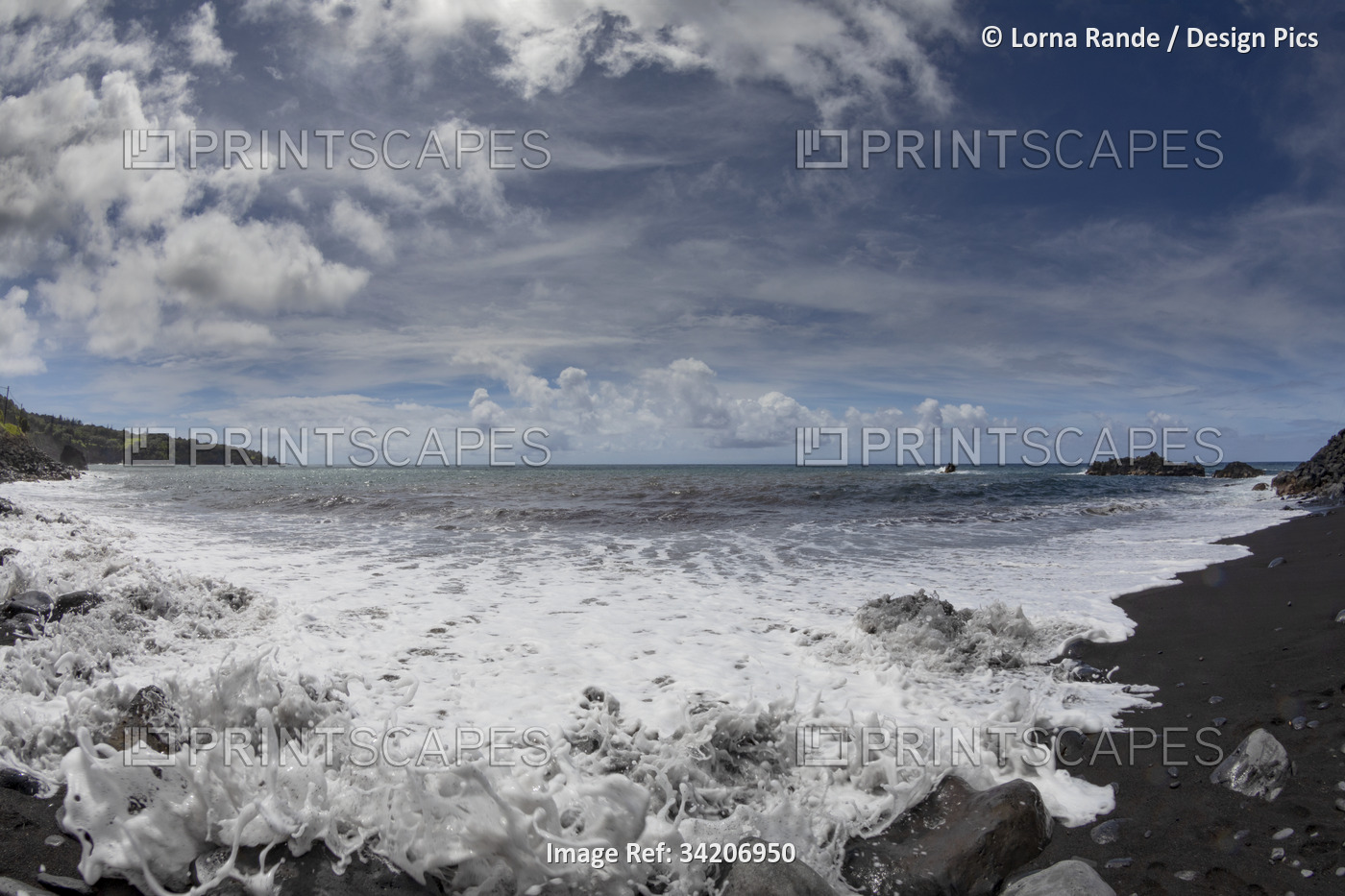 Scenic view of the Pacific Ocean from a black lava sand beach with sea surf and ...