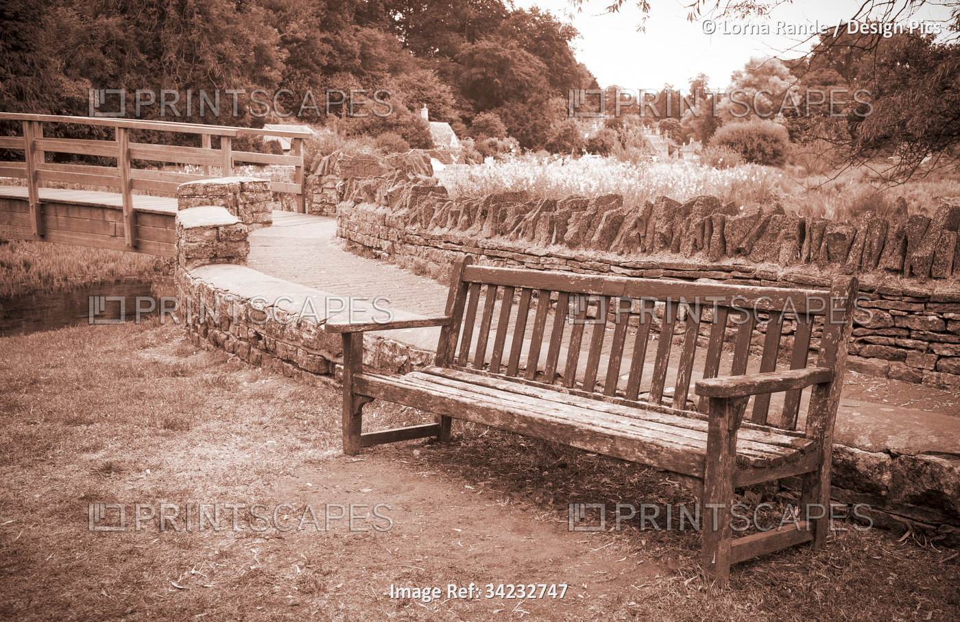 Sepia tone scene of a bench in a garden area in The Cotswolds, UK;  Bibury, ...