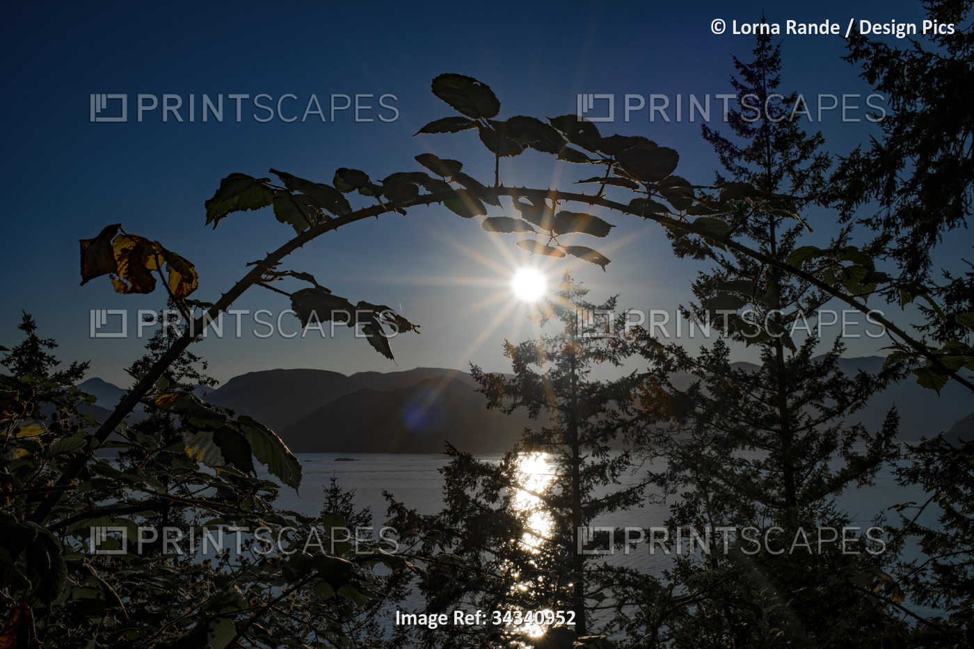 Sunburst at sunset over the coastline of British Columbia, with sunlight ...