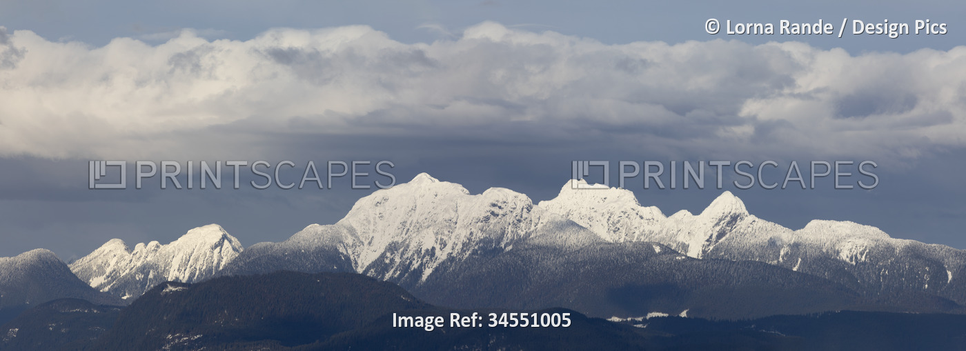 Dramatic vista of a ridge of snow-capped mountain peaks of the Coast Mountains ...
